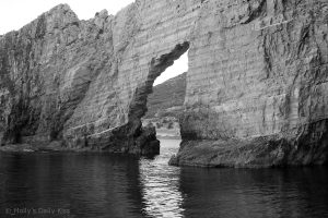 Hole in the cliff wall surrounded by sea