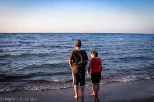 Siblings standing on the shore