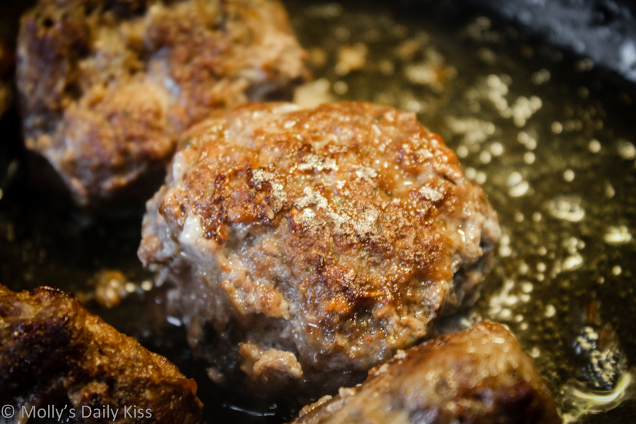 Meatballs sizzling in the pan