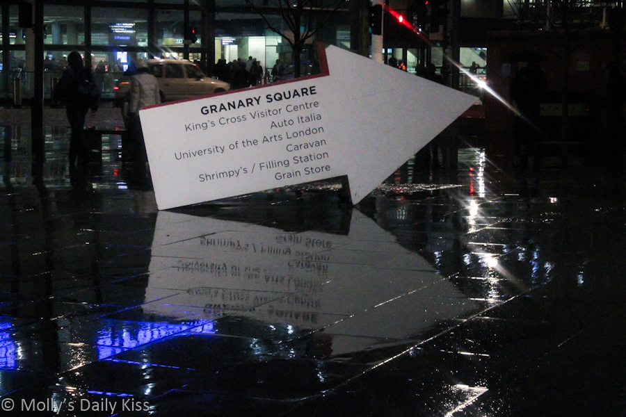 Sign reflected in rain outside Kings Cross Station