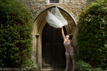 Bride thoring away her veil outside church