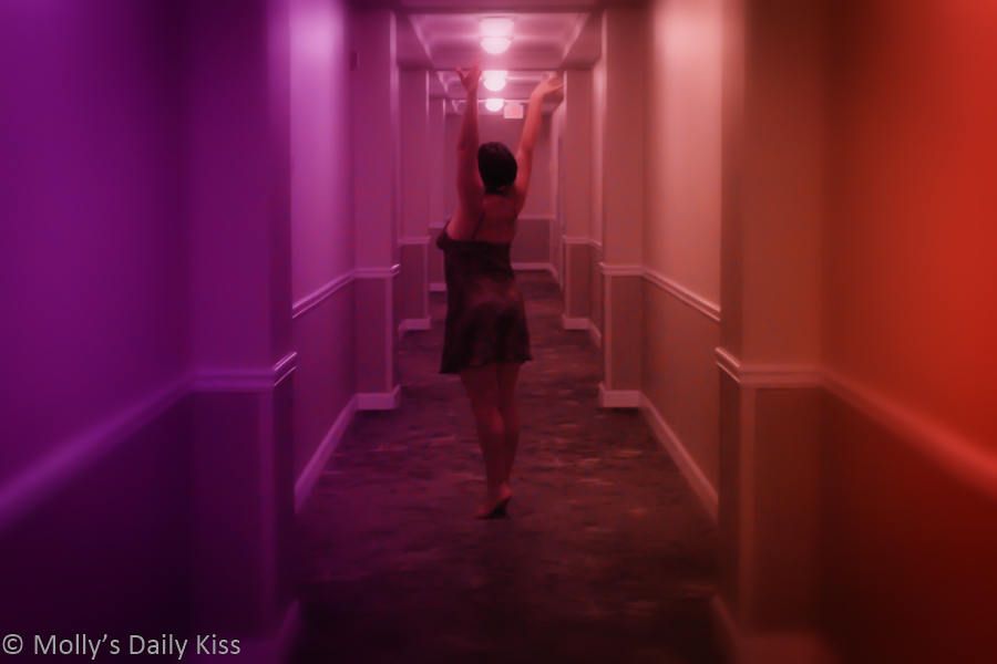 Molly dancing in purple hotel corridor