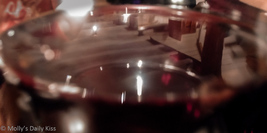 Restaurant reflections in glass of red wine