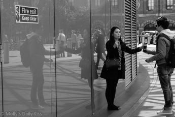 Reflection of young couple in the glass at Kings Cross Station, who are they
