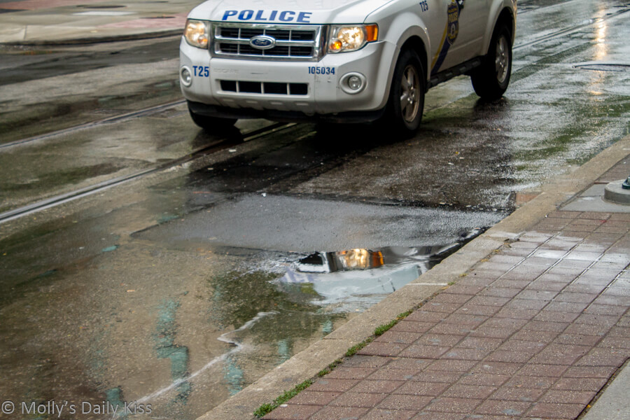 police car reflection in street mirror of rain