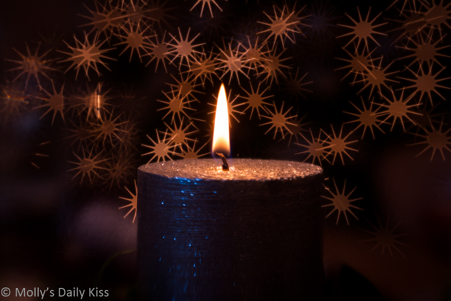 Single candle flame against bokeh star back ground. Image name define the darkness