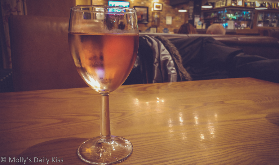 Glass of Rosa wine on table in pub