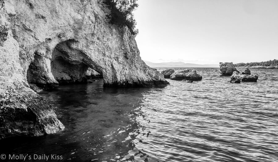 rocky cliff and cave with sea water in black and white