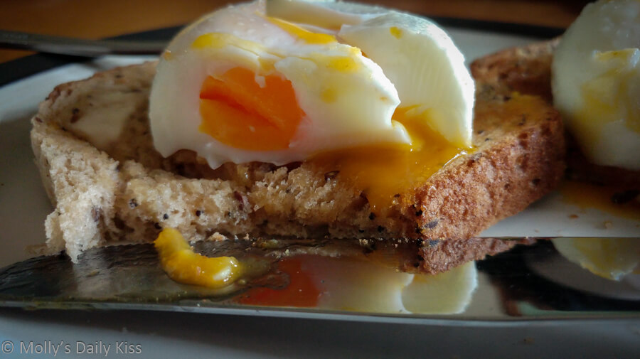 poached eggs on toast reflected in knife