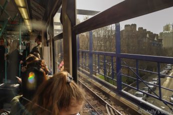 people on the docklands light railway with sun flare coming in through the window