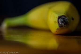 Macro shot of end of Banana reflected in table top