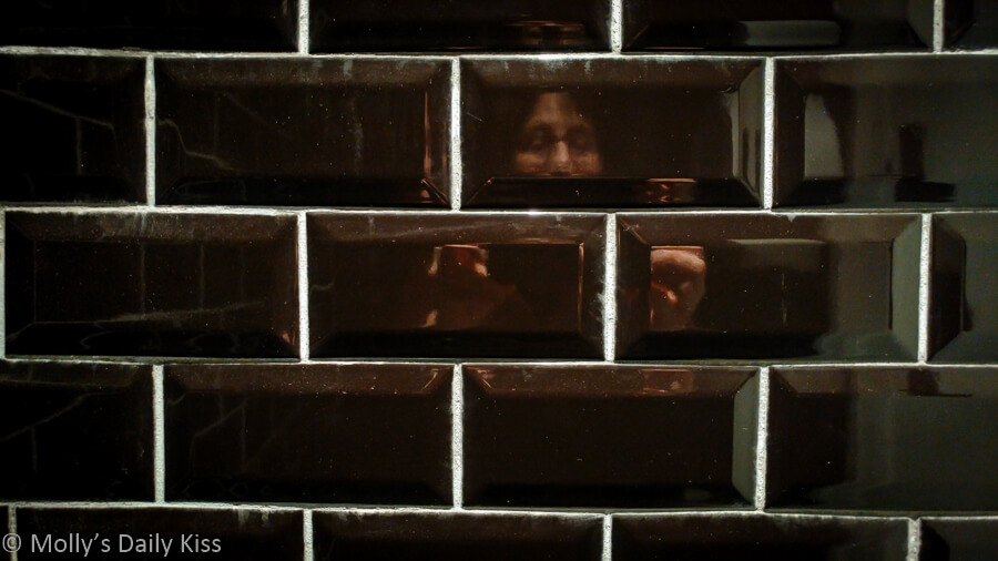 self portrait in black brick toilet wall is a bit of solitude