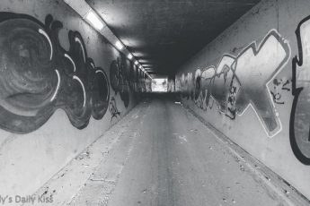 black and white of underpass tunnel with graffiti on the walls