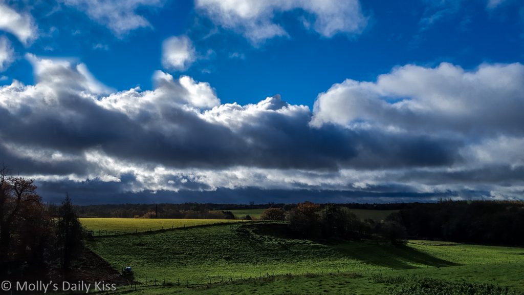 white and black big balls of cotton clouds over autumn landscape