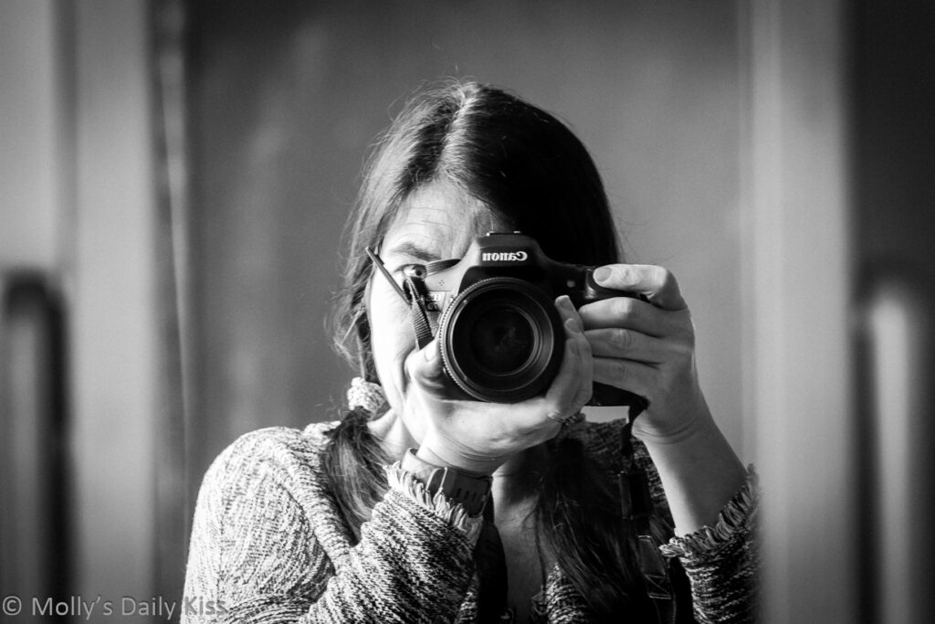 self portrait in the mirror with camera in black and white
