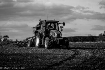 Tractor plowing field in black and white
