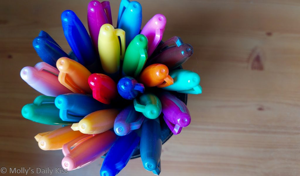 Looking down into pot of colourful pens